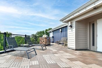 A patio with a table and chairs is surrounded by a black railing.